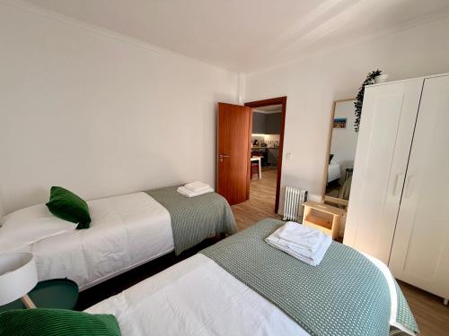 a bedroom with two beds and a mirror at Casinha do Cercal in Cercal