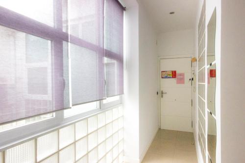 pusty korytarz z oknem i drzwiami w obiekcie Apartamento Alvarez w Maladze
