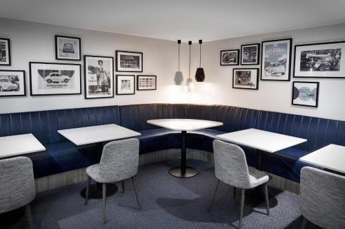 a dining room with tables and chairs and pictures on the wall at Leonardo Royal Hotel Oxford in Oxford