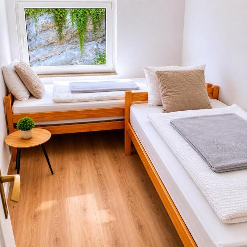 two beds in a room with a window at Rose 2 Apartment in Jajce