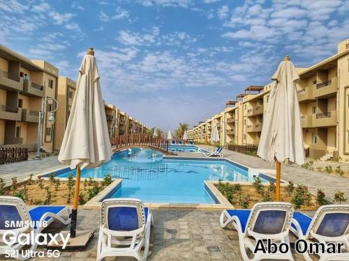 a pool at the resort with umbrellas at Halaشاليه in Ras Sedr