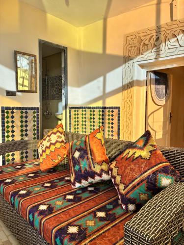 a couch with colorful pillows on it in a room at Riad Serendipity in Fez