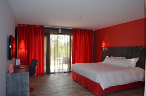 a bedroom with a large bed with red walls and curtains at Hôtel du Bois Blanc Domaine d'Epeyssoles Georges Blanc in Vonnas