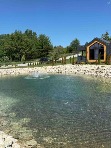 a house on the shore of a body of water at Sosna Park Будиночки in Vynnychky