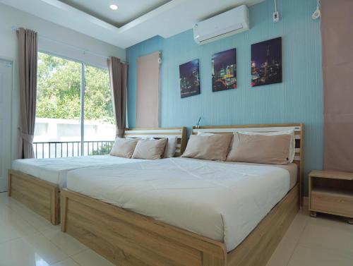 a bedroom with a large bed with a large window at MUJI House Poolvilla Pattaya in Na Jomtien
