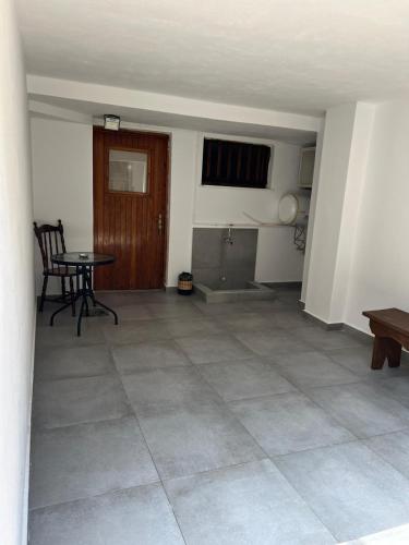 ein leeres Wohnzimmer mit einem Tisch und Stühlen in der Unterkunft Studio Δωμάτιο in Eretria