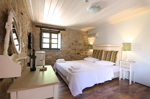 a bedroom with a large white bed and a sink at Semantron Traditional Village in Diakopto