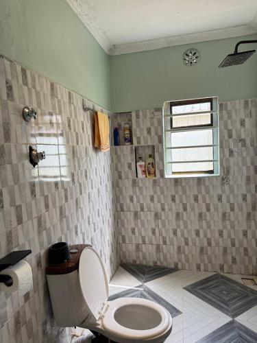 a bathroom with a toilet and a window in it at Villa maasai in Kimana