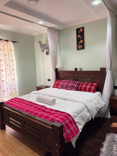 a bedroom with a large bed with a red and white blanket at Villa maasai in Kimana