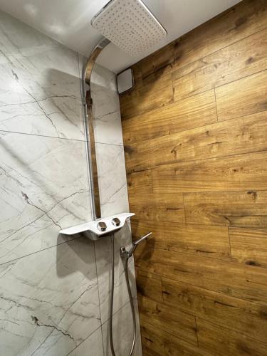 a shower in a bathroom with a marble wall at Willa Stornia in Jastarnia