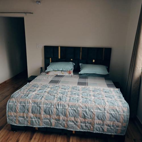 a bedroom with a large bed with two pillows at Nature Nest Farms in Chūharpur