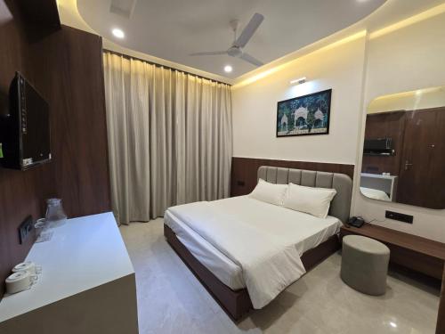 a bedroom with a bed and a television in it at Shree Radha Raman Sarkar Dham in Vrindāvan