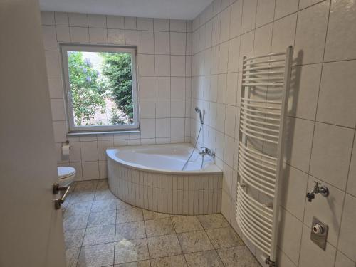 a bathroom with a tub and a window at Zum alten Hafen Wesenberg in Wesenberg