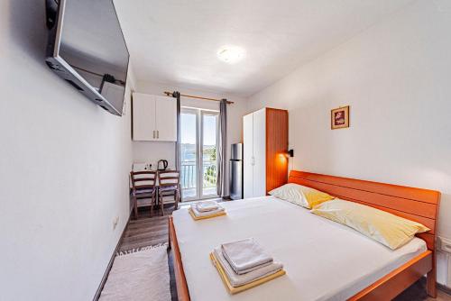 a small bedroom with a bed and a tv at Siriščević Apartment in Korčula