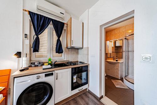 a kitchen with a washing machine and a sink at Siriščević Apartment in Korčula