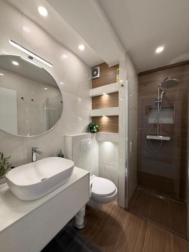 a bathroom with a sink and a toilet and a mirror at Apartments Ostojic in Krk