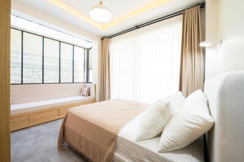 a bedroom with a bed and a window with a bath tub at Villa Palma 2 in Beyobası