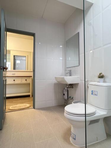 a bathroom with a toilet and a sink at บ้านเคียงคลื่น in Cha Am