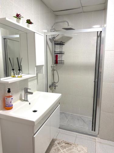 a white bathroom with a sink and a shower at King Suite SS18 in Istanbul