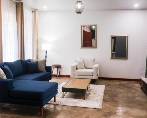 a living room with a blue couch and a table at Torriam Apartments in Chongwe