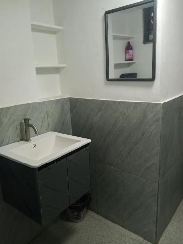 a bathroom with a sink and a mirror on the wall at Su Staycation Minimalist in Naic