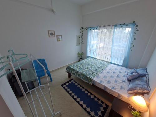 a small room with a bed and a window at Jorhat Homestay in Jorhat