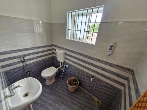 a bathroom with a toilet and a sink at Jorhat Homestay in Jorhat