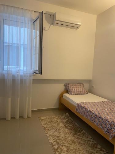 a bedroom with a bed and a window and a rug at Marina Luka in Bar