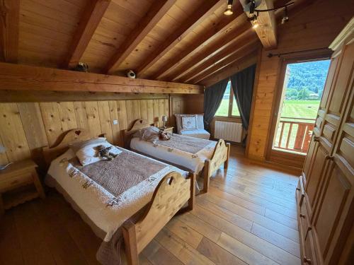 a bedroom with two beds in a wooden house at Chalet Pétérets in Samoëns