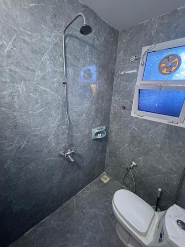 a bathroom with a shower with a toilet and a window at Heritage House in Nizwa