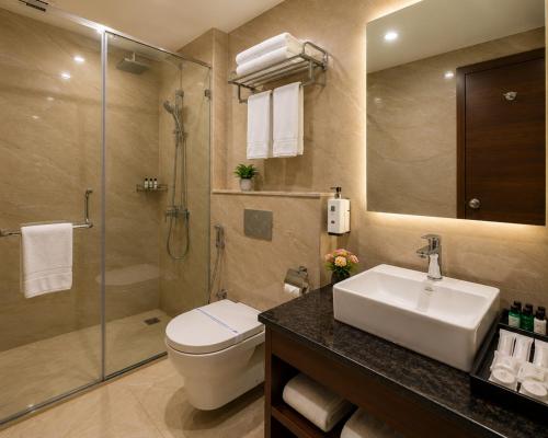 a bathroom with a sink and a toilet and a shower at Hotel The Grand Villa by Signature Stayz Near International Airport in New Delhi