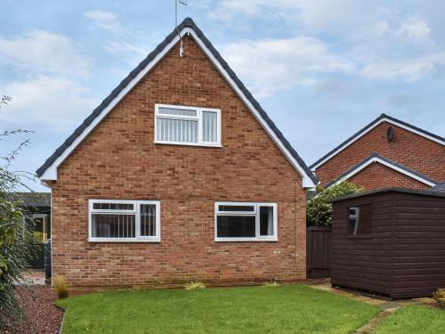 a brick house with white windows and a yard at Pine Hill Lodge in Guisborough