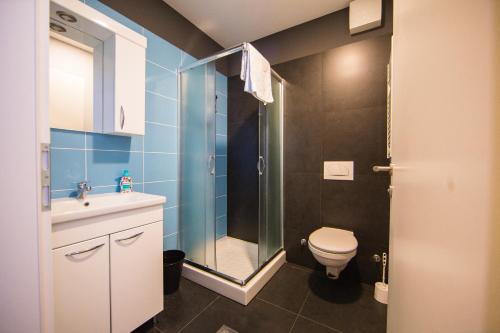 uma casa de banho com um chuveiro, um WC e um lavatório. em Hostel Villa Domus em Koper