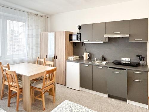 a kitchen with a wooden table and a table and chairs at ViVi Apartments in Liptovský Mikuláš