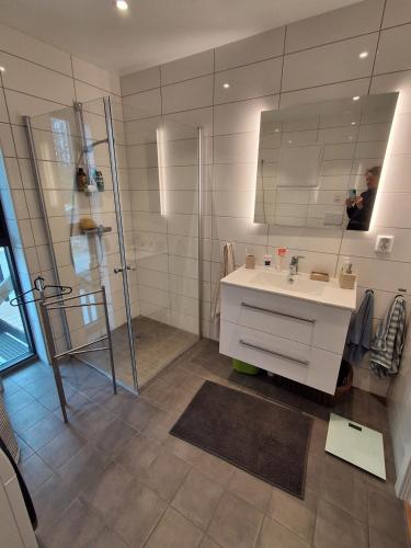 a bathroom with a sink and a shower and a mirror at Fjordhytte-24 in Bøvågen