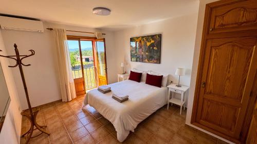 a bedroom with a white bed and a window at Sa Tanca in Pòrtol