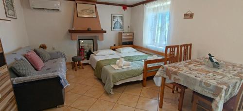 ein Schlafzimmer mit einem Bett, einem Tisch und einer Couch in der Unterkunft Dalis House in Astris