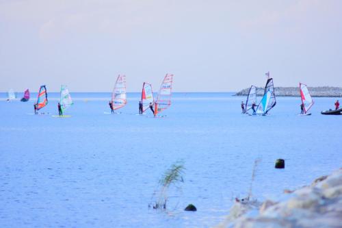 a group of people on a beach with sailboards in the water at Bajkowa Plaża - Amber in Gdańsk