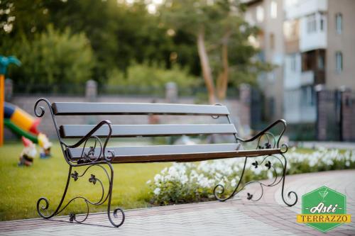 a park bench sitting on a sidewalk in a park at Park Hotel in Karagandy
