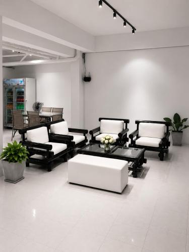 a room with black and white chairs and a table at Holiday House Kata & Karon Phuket Hotel in Kata Beach