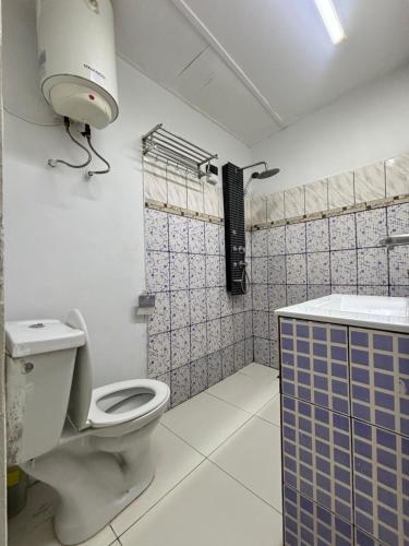 a bathroom with a toilet and a sink at Résidence meublée du boss in Abidjan