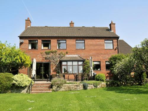 a brick house with a lawn in front of it at Field House in Baschurch