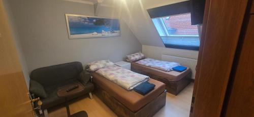 a small living room with a chair and a couch at Sonnige Ferienzimmer WHV in Wilhelmshaven