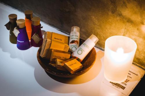 a table with a candle and a basket of cosmetics at Garcinia Leaf in Hikkaduwa