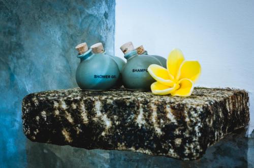 three blue vases and a yellow flower on a table at Garcinia Leaf in Hikkaduwa