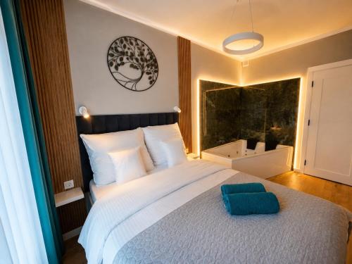 a bedroom with a large bed with a blue pillow on it at Caroline Jacuzzi Apartments in Nowy Dwór Mazowiecki