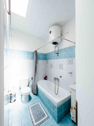 a blue and white bathroom with a tub and a toilet at Ormos Isternia House in Istérnia
