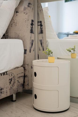 a bedroom with a bed and a white nightstand at Avis Hotel in Novalja