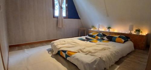 a bedroom with a bed with pillows and a window at Mon petit chalet in Puycornet