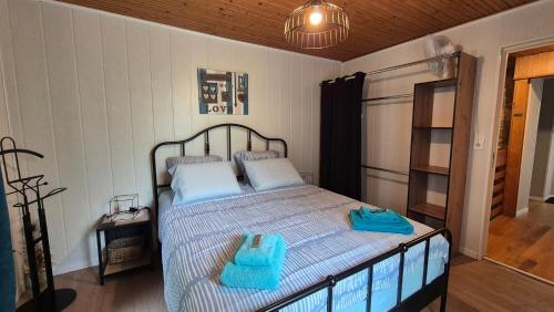 a bedroom with a bed with two blue towels on it at Mon Refuge B&B in Jougne